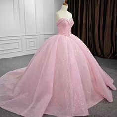 a pink ball gown is displayed on a mannequin