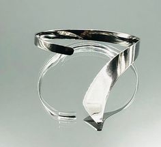 *About me: 925 silver cuff bangle. I think I am a stylish modernist twist on the torque wristband with a feature that flows over the hand. *Size: Approx. length 21cm /8.26 inches , inner length 18cm / 7 inches including gap, width 1.3cm / 0.51 inches at widest graduating to 0.5cm /0.19 inches, gap 3cm / 1.18 inches flexible *Weight: Approx. 17.8 grams *Hallmark: 925 *Age: Vintage *Condition: Good vintage condition *Gift boxed to your door ** A vintage item that has been pre-loved, history of wea Modern Sterling Silver Cuff Bracelet Bangle, Modern Sterling Silver Cuff Bracelet With Polished Finish, Modern Sterling Silver Open Cuff Bangle, Contemporary Sterling Silver Bangle Bracelet For Formal Events, Modern Polished Cuff Bangle, Contemporary Sterling Silver Bangle For Formal Occasions, Modern Cuff Bangle With Polished Finish, Silver Bangle With A Modern Twist, Adjustable Cuff Bracelet With Polished Finish