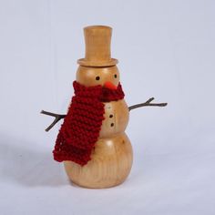 a wooden snowman wearing a red scarf and hat