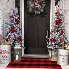 two christmas trees are decorated with red and silver tinsels in front of a black door