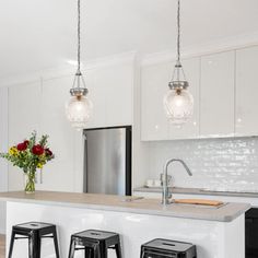 a kitchen with three stools and a center island