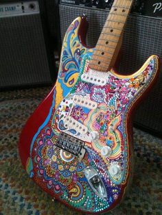 an electric guitar is decorated with colorful designs