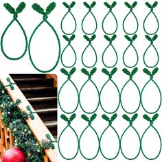 christmas garlands with green leaves and lights hanging on the side of a wooden railing