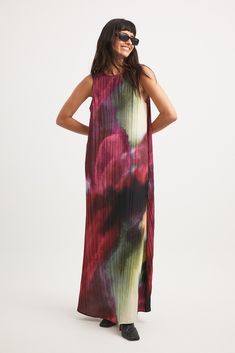 This maxi dress is sleeveless and features a relaxed flowy fit and a textured material. It has a printed design and a deep back. Flowy Multicolor Floor-length Maxi Dress, Multicolor Printed Maxi Sleeveless Dress, Bohemian Pleated Maxi Dress For Beach, Bohemian Pleated Maxi Dress For Party, Multicolor Floral Print Maxi Sleeveless Dress, Flowy Abstract Print Maxi Dress, Flowy Maxi Dress With Abstract Print, Chic Sleeveless Maxi Dress With Abstract Print, Spring Red Maxi Dress With Abstract Print