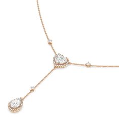 Inspired by a lariat necklace, this piece has a Y-shaped silhouette and two sparkling pendants. The chain necklace holds a heart pendant dotted at the center with a heart-cut diamond framed by a heart-shaped halo of petite round diamonds. Gently dropping from the heart pendant is a pear-cut diamond haloed by round diamonds. This necklace is a piece of everyday fine jewelry that can effortlessly enhance your daily wardrobe. Luxury Wedding Dangle Necklaces, Elegant Necklace With Heart Charm And Dangle, Elegant Heart Charm Dangle Necklace, Timeless Drop Necklace For Wedding, Timeless Drop Necklaces For Wedding, Elegant Drop Lariat Necklace With Cubic Zirconia, Elegant Cubic Zirconia Drop Lariat Necklace, Wedding Lariat Necklace With Adjustable Diamond Chain, Diamond Lariat Necklace With Adjustable Chain For Wedding