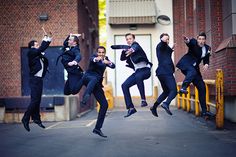 a group of young men jumping in the air with their arms up and legs spread out