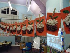 an office decorated for christmas with red and white decorations hanging from the ceiling, on orange paper