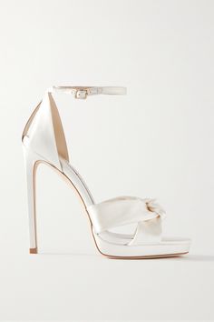 Sleek, elegant and timeless, Jimmy Choo's 'Rosie' sandals are the perfect bridal style to take your from your first step down the aisle to dancing the night away at the reception. They're made from ivory satin with knotted toes and are set on towering stiletto heels balanced by slight platforms and ankle straps for stability. We especially love them peeking out from a high slit. Bride Heels, Jimmy Choo Bridal, Satin Sandals, Shoes Heels Classy, Wedding Shoes Bride, White High Heels, White Wedding Shoes, Jimmy Choo Heels, Bridal Heels