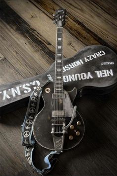 an electric guitar sitting on top of a wooden floor next to a black and white case