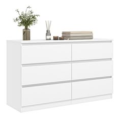 a white dresser with books and vases on top