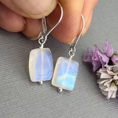 ✦These beautifully polished high quality rainbow moonstones rectangles have the gorgeous flashes of blue, turquoise and green opalescence.  The stones are rectangular shaped, center drilled and measure about 1/2 inch by 3/8. They and wire wrapped with sterling silver head pins and hang from all sterling silver ear wires. ✦Earring length is about 1.25 inches. Available with your choice of sterling silver lever back or French hook ear wires. Please select ear wire style at check out. ✦Your jewelry will be packaged in a beautiful and reusable organza bag. All items will be placed in the same organza bag. If you need a separate bag for each item, please leave a comment at check out. ✦To receive your item in a gift box with a colorful ribbon, please purchase the gift wrapping option at check ou Colorful Ribbon, Diy Jewelry Projects, Jewelry Card, June Birthstone, Head Pins, June Birth Stone, Blue Turquoise, Jewelry Projects, Ear Wire