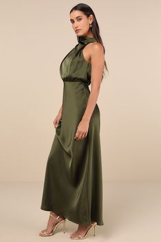 The Lulus Distinctive Charm Olive Green Satin Asymmetrical Maxi Dress is ready to party with the best (and most stylish) of them! Ultra-sleek woven satin shapes this chic dress that has a trendy mock neckline and a blousy, asymmetrical bodice with gathering. The fitted waist tops a figure-skimming, A-line maxi skirt. Top button closures secure atop a keyhole-style cutout at the back. Hidden back zipper/clasp. Fit: This garment fits true to size. Length: Floor length. Size medium measures 60.5" from shoulder to hem. Bust: Great for any cup size. Waist: Fitted - very fitted at natural waist. Hip: Loosely Fitted. Undergarments: May be worn with a strapless bra, adhesive bra, petals, or no bra. Fabric: Fabric has no stretch. Lined. Shell: 100% Polyester. Lining: 97% Polyester, 3% Spandex. Hand Satin Floor Length Dress, Olive Green Dress Outfit Wedding, Army Green Dresses, Army Green Dress Outfit, Olive Green Satin Dress, Asymmetrical Gown, Olive Bridesmaid Dresses, Green Dress Outfit, Green Satin Dress