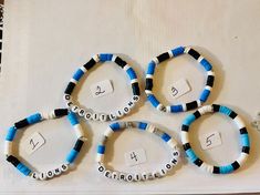 four blue and white bracelets sitting on top of a table