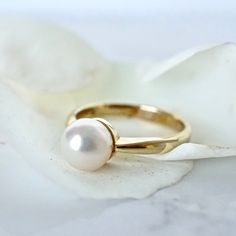 Simple 14k Yellow Gold straight shank with a 7mm Akoya Japanese Cultured White Pearl. Simple, feminine, and classic-perfect promise or engagement ring for your special someone.  7.25mm Fine Cultured Pearl Super lustrous White round pearl,  with rose, and slight green overtones 14 Karat Yellow Gold Ready to ship in size 6- sizable :: In the PERSONALIZED SECTION please enter your ring size and if you have any specifications, time frames, and or change of address We NOW offer Vintage Jewelry from o Classic Jewelry Ring With Timeless Design, White Gold Rings With Timeless Design, Classic Timeless Round Band Jewelry, Timeless White Gold Rings, Timeless Brilliant Cut Pearl Ring For Anniversary, Classic White Gold Pearl Ring With Prong Setting, Classic Rings With Timeless Design For Anniversary, Classic Round Cut Jewelry With Timeless Design, Classic Jewelry With Timeless Design For Anniversary