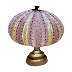 a lamp that is sitting on top of a metal stand with a purple and yellow striped shade