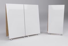 two white cabinets sitting next to each other on top of a gray floor with wheels