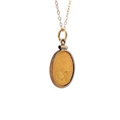 This stylish pendant necklace made from 14 karat yellow gold. The pendant has a cool coin design and hangs on a wheat chain. The detailed craftsmanship of the pendant makes it stand out and will add a unique touch to any outfit. The shiny gold finish gives it a classy look that's perfect for any occasion, whether you're dressing up or going casual. This necklace is a great choice for anyone who loves modern, elegant jewelry. Vintage Yellow Gold Tarnish Resistant Medallion Necklace, Vintage Yellow Gold Tarnish-resistant Medallion Necklace, Classic Yellow Gold Coin Pendant Necklace, Vintage Yellow Gold Round Coin Necklace, Antique Necklace With Oval Coin Pendant, Classic 14k Gold Coin Necklaces, Antique Coin Pendant Necklace, Antique Oval Coin Pendant Necklace, Antique Engraved Yellow Gold Coin Necklace