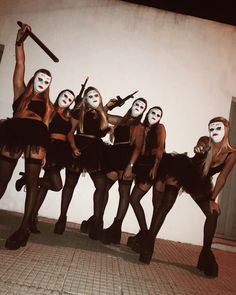 a group of women dressed in costume posing for a photo with their faces painted white