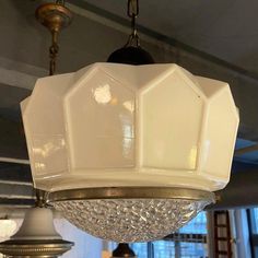 a chandelier hanging from the ceiling in a room with other lights and fixtures