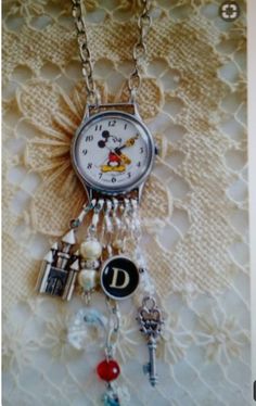 a clock with charms attached to it sitting on a table