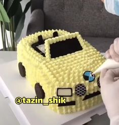 a person is decorating a cake in the shape of a car