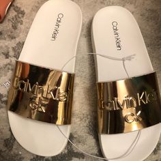 Some Nice Calvin Klein Slides To Wear Out And About Or Inside The House. Size 6m, Fits Up To A Womens 7.5 Without Socks. Unisex, Item Is New With Tags Casual Gold Flip Flops With Flat Heel, Casual Gold Flat Heel Flip Flops, Gold Slippers For Summer, Casual Closed Toe Gold Flip Flops, Casual Gold Closed Toe Flip Flops, Gold Flat Casual Flip Flops, Gold Flat Slides For Vacation, Gold Round Toe Slides For Beach, Trendy Gold Synthetic Flip Flops