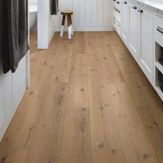 a kitchen with white cabinets and wood floors