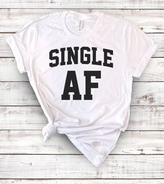 This "Single AF" design is the perfect shirt for anyone that is single with a sense of humor! All shirts are unisex (Male & Female) and any tee with rolled sleeves is done just for the picture. Unisex Cotton Shirt With Funny Text, Unisex Casual Shirt With Funny Text, Casual Shirt With Funny Text In Ring-spun Cotton, Casual Slogan Shirt In Ring-spun Cotton, Casual Ring-spun Cotton Shirt With Funny Text, Casual Ring-spun Cotton Shirt With Slogan, Unisex Casual Slogan Shirt, Casual All-gender Slogan Shirt, Ugly Christmas Sweater Couples