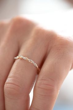 a woman's hand with a gold ring on her left hand and a diamond in the middle