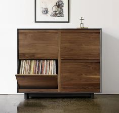 an entertainment center with record players and artwork on the wall