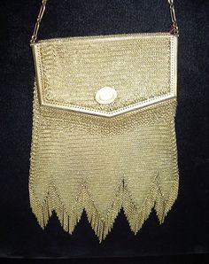 Whitting & Davis named this purse the Princess Mary after the British Royal Family, they considered this design that special, the "Hall Marked" gold fine mesh body has a 5 zig zag bottom with chain fringe hem swaying to & fro. Envelope Shaped body with delicate 1/2" metal fringe also cascades from the framed purse flap-over top which is adorned with an engraved medallion, that opens to reveal the body suspended from a gold metal  bar soldered to the sides,. This Purse is in pristine condition re Designer Gold Evening Bag With Chain Strap, Designer Gold Shoulder Bag For Evening, Vintage Gold Shoulder Bag With Chain Strap, Yellow Gold Rectangular Party Bag, Traditional Gold Shoulder Bag For Formal Occasions, Traditional Gold Formal Shoulder Bag, Traditional Formal Gold Shoulder Bag, Designer Handmade Gold Bag, Gold Rectangular Shoulder Bag For Celebration