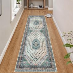 a long hallway with a rug on the floor next to a shelf and potted plant