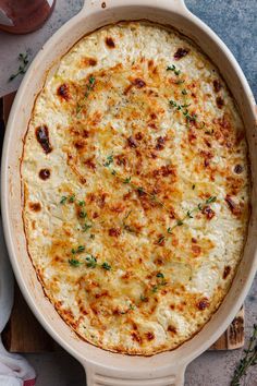 a casserole dish with cheese and parsley on the side, ready to be eaten