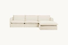 a white couch with a footstool sitting on it's back end, against a white background