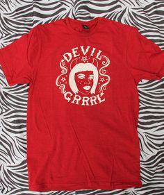 Be the devil you were born to be! Show off your demonic side with this cute, grrrl-approved Devil Tee. Dare to be bold and with pride! Each garment is hand screen printed by yours truly! Super soft unisex antique red tee, made with 100% combed and ring-spun cotton. Shirts are manufactured in ethical WRAP* certified factories. Unisex sizes XS-3XL.*WRAP (Worldwide Responsible Accredited Production) is a globally recognized, independent 3rd party certifying body whose mission is to promote ethical, Red Cotton Grunge T-shirt, Punk Red T-shirt For Halloween, Red Band Merch Tops With Screen Print, Punk Style Red T-shirt For Halloween, Red Band Merch Top With Screen Print, Red Cotton Top With Back Print, Red Punk T-shirt With Screen Print, Red Band Merch T-shirt For Halloween, Red Punk Style Screen Printed Top