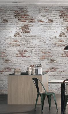 two chairs and a table in front of a brick wall with a lamp on it