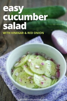 a white bowl filled with cucumber salad on top of a blue and white napkin