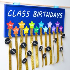 a class birthday sign hanging on a wall with gold streamers and star pins attached to it