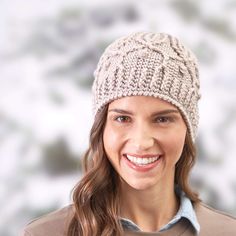 a smiling woman wearing a knitted hat