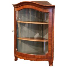 a wooden display case with glass doors and wood trimmings on the bottom shelf