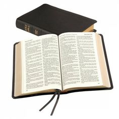 an open book sitting on top of a table next to a black leather bound book