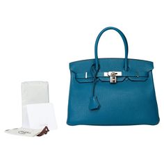 Amazing​​ ​​and​​ ​​Bright​​ ​​Hermes​​ ​​Birkin​​ ​​30​​ ​​handbag​​ ​​in​​ ​​Blue​ ​​Togo​​ ​​leather​​ ​​,​​ ​​palladium​​ ​​silver​​ ​​metal​​ ​​trim​​ ​​,​​ ​​double​​ ​​handle​​ ​​in​​ ​​blue​ ​​leather​​ ​​for​​ ​​hand​​ ​​carry Flap​​ ​​closure Blue​​ ​​leather​​ ​​inner​​ ​​lining​​ ​​,​​ ​​a​​ ​​zippered​​ ​​pocket,​​ ​​a​​ ​​patch​​ ​​pocket Signature:​​ ​​"Hermès​​ ​​Paris​​ ​​Made​​ ​​in​​ ​​France​​ ​​" Year:​​ ​​Q​​ ​​square​​ ​​(2013) Dimensions:​​ ​​30x22x15​​ ​​cm​​ ​​(11,8x8,7x5,9​​ ​​Inches) Reference:​​ ​​101731 General​​ ​​condition:​​ ​​7/10 Sold​​ ​​with​​ ​​tirette,​​ ​​clochette,​​ ​​padlock​,​ ​keys​ ​and​ ​raincoat In​​ ​very​ ​good​ ​​condition​​ ​​despite​​ ​​wear​​ ​​marks​​ ​​on​​ ​​the​​ ​​leather​​ ​​and​​ ​​trim​​ ​​(scratches​) Option in addition: Certif Birkin 30, Togo Leather, Hermes Birkin 30, Hermes Paris, Metal Trim, Hermes Birkin, Blue Leather, Fashion Handbags, Made In France