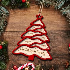 a christmas tree ornament hanging on a wooden table with candy canes and candies