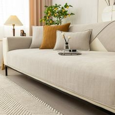 a living room with a white couch and yellow flowers on the table next to it