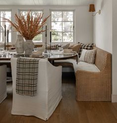 a living room filled with furniture and a large vase on top of a wooden table