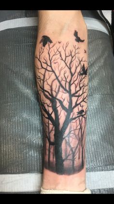 a person with a tree and birds tattoo on their leg