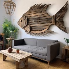 a living room with a couch, coffee table and fish wall art