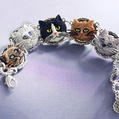 Five faces of wonderful cats adorn this bracelet. They are molded for detail and dimension, hand painted and mounted on the panels of our link bracelet. Adjustable to fit 7 to 8 wrists, the bracelet has a burnished silver finish, is lightweight and easy to clasp. So irresistible, you may want to adopt a litter of 6 to spread love and awareness. You know you're a cat person if you can identify each face on this bracelet as some feline you've known or loved or helped. And, for every bracelet we se Affordable Novelty Cat Design Jewelry, Cat Memorial Jewelry, Lady Cat, Tom Y Jerry, Cat Faces, Cat Bracelet, Lovers Bracelet, Gift For Cat Lover, Silver Link Bracelet