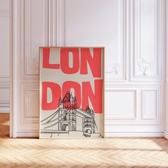 a poster with the words london on it in front of a white wall and wooden floor