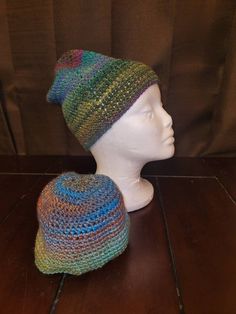 a crocheted hat and a mannequin's head on a wooden table